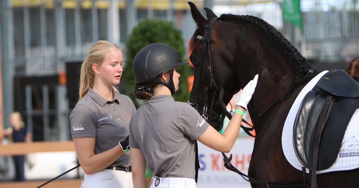 Twee studenten van Lentiz staan naast Fries paard op Horse Event