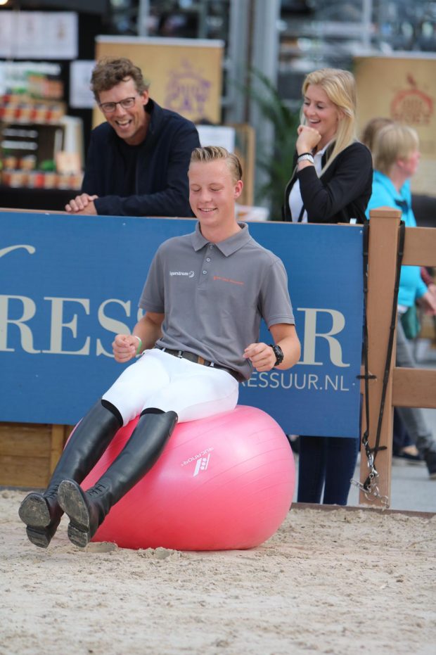 Student Lentiz zit op evenwichtsbal op Horse Event