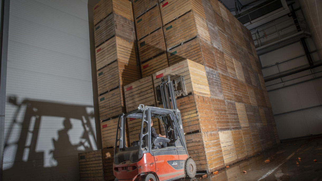 Heftruck in magazijn met houten kratten