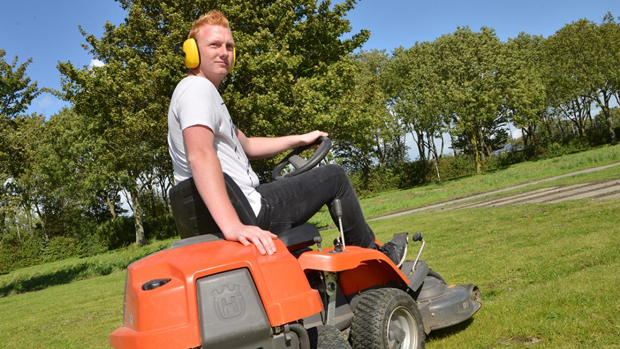 Jongen op zitmaaier