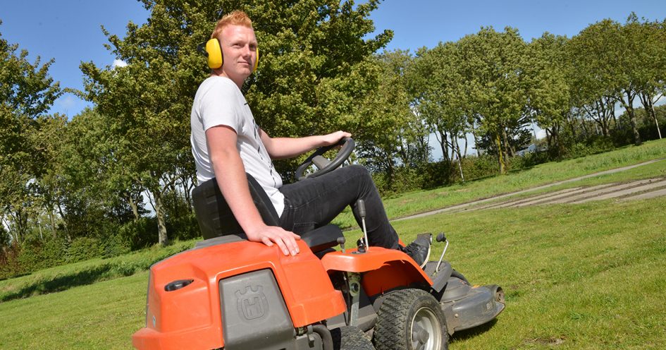 Jongen op zitmaaier