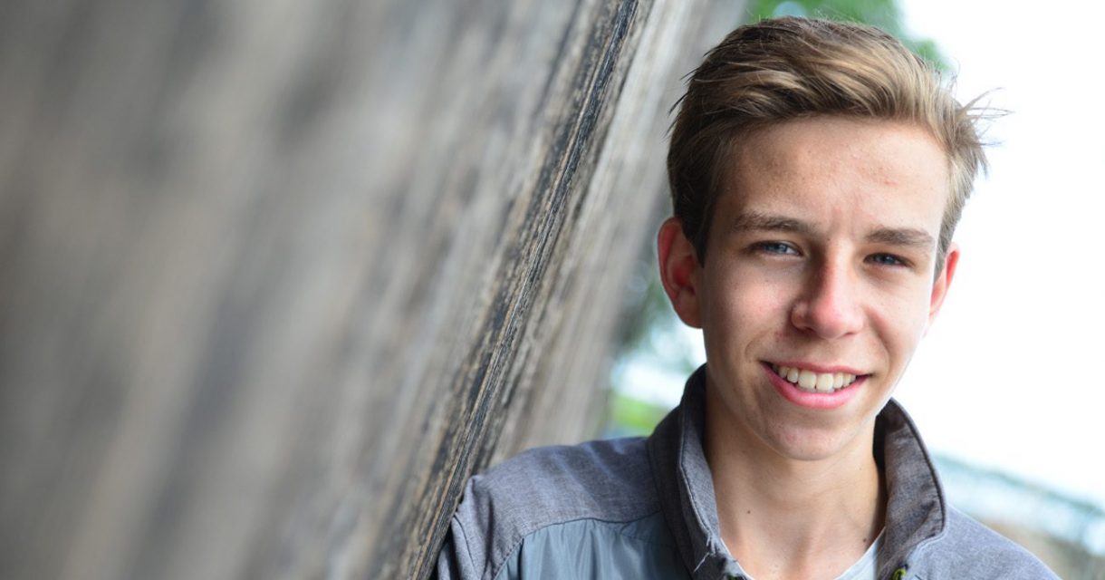 student staat tegen een deur geleund