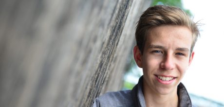 student staat tegen een deur geleund