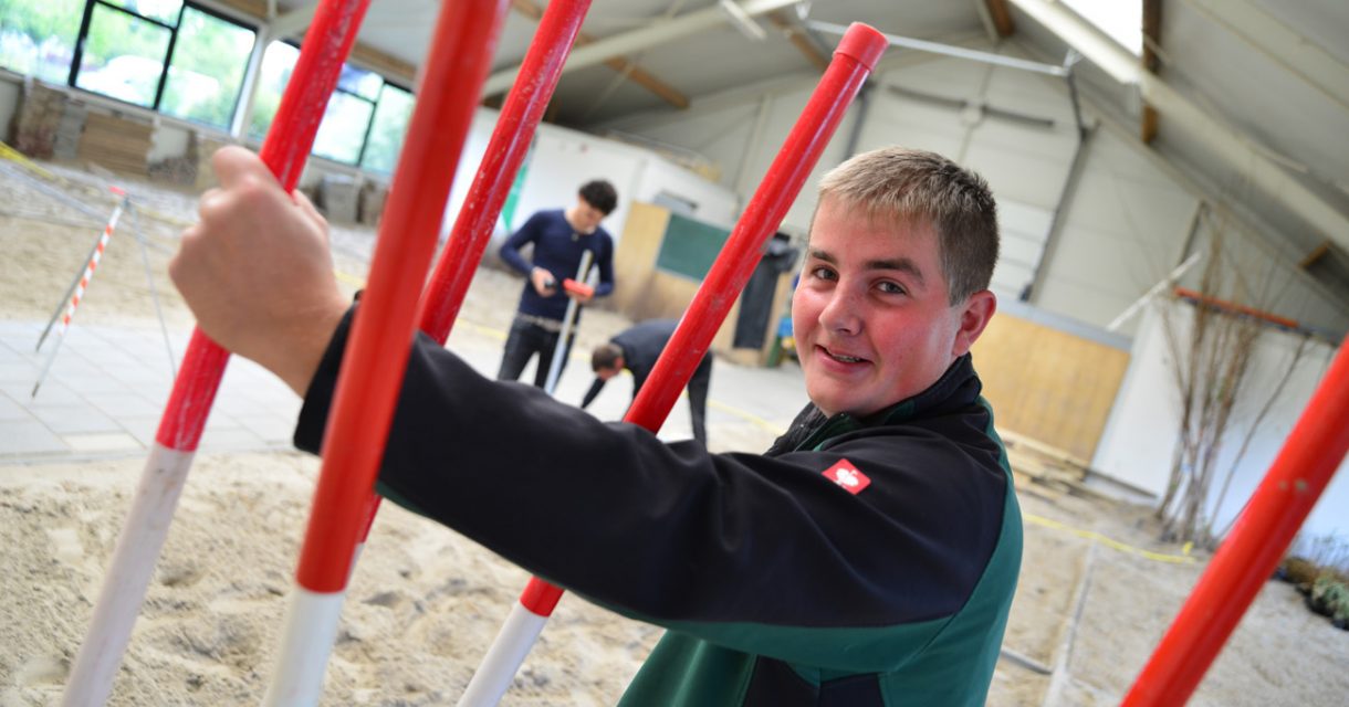 Jongen houdt landmeetpalen vast