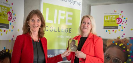 Wethouder van Aaken neemt boekje LIFE College in ontvangst