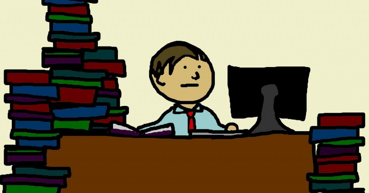 Docent achter bureau met stapels werk