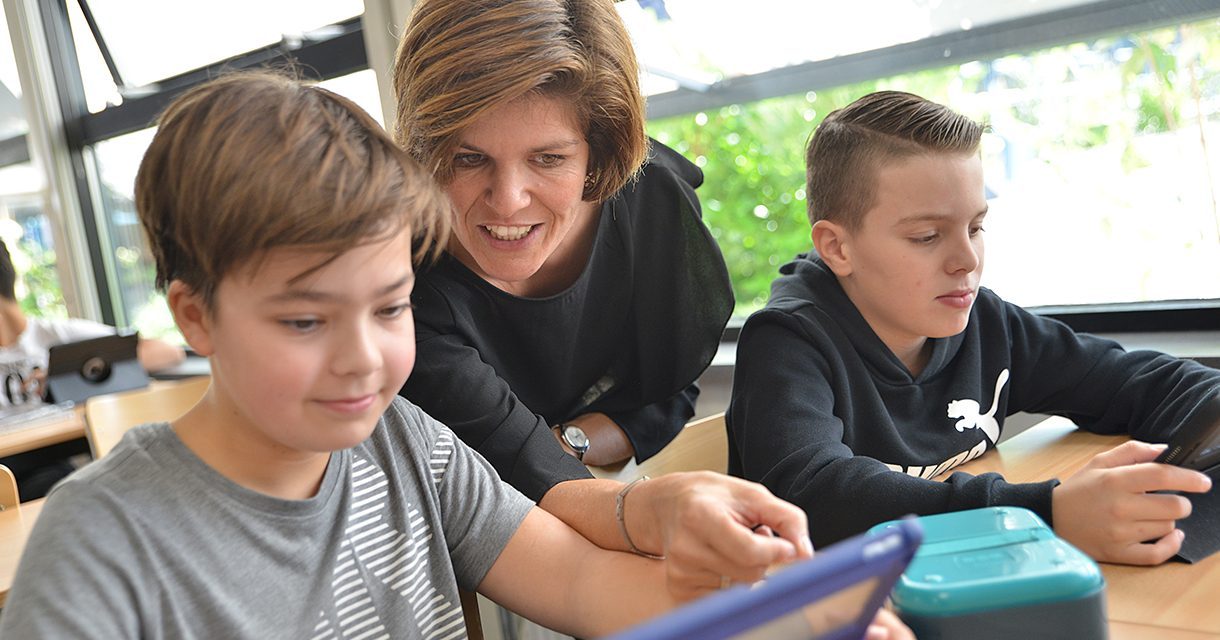 Een docent begeleidt een leerling