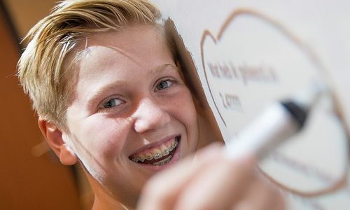 Leerling schrijft op digitaal bord.