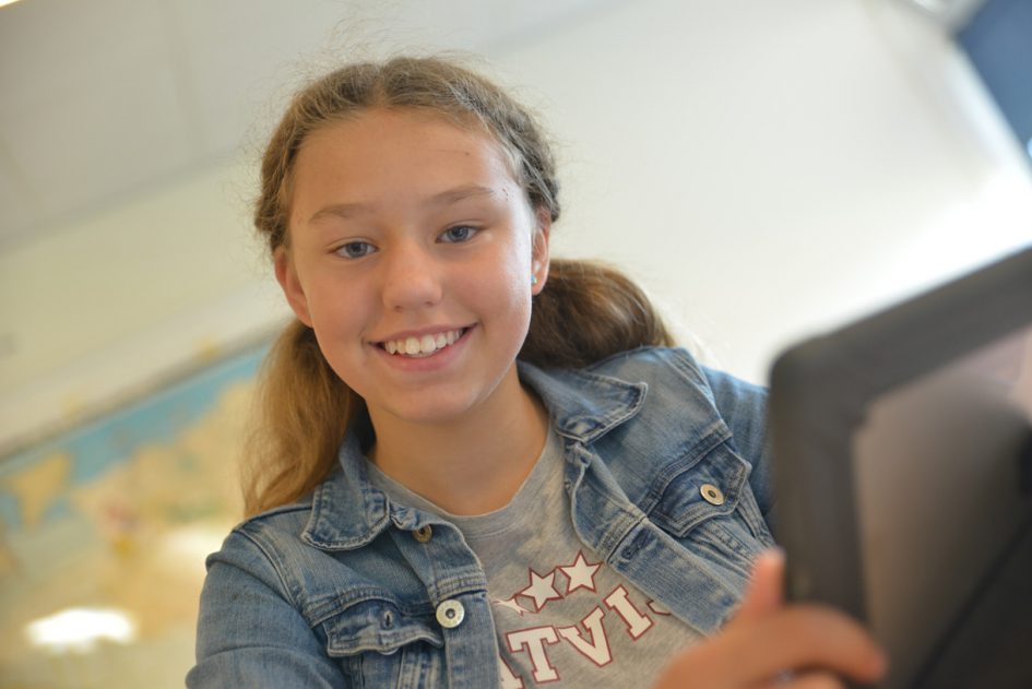 Meisje lacht in de camera.